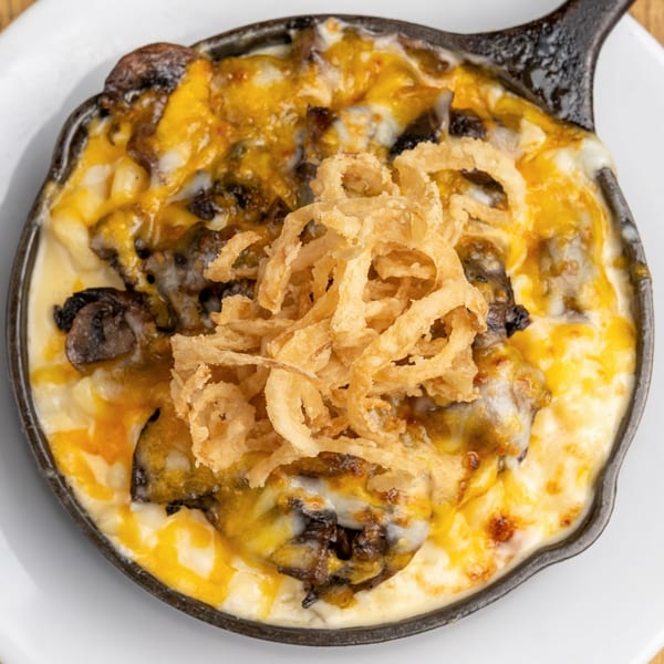 Morgan's Brooklyn Barbecue mac and cheese with burnt ends and crispy fried onions in a skillet.